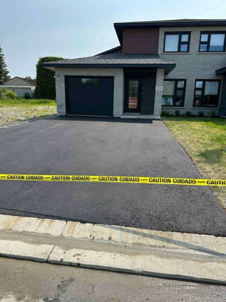 A driveway surrounded by yellow caution tape, indicating a restricted or hazardous area.
